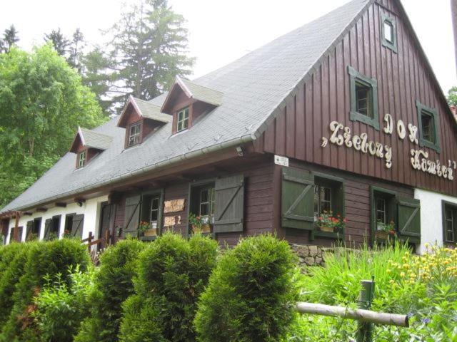 a building with a sign on the side of it at Dom Zielony Kamień z jacuzzi i bilardem in Szklarska Poręba