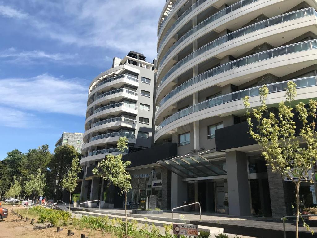 an apartment building in front of a parking lot at Departamento con Amenities in Pinamar