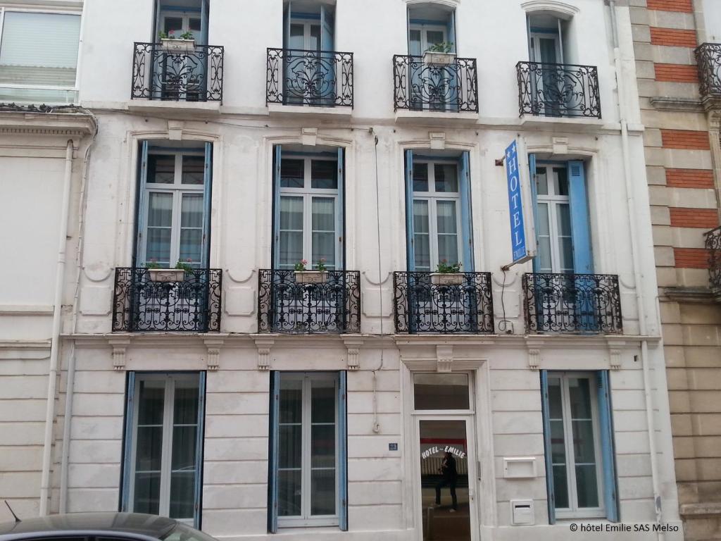 un edificio con balcones en un lateral en Hôtel Emilie en Royan