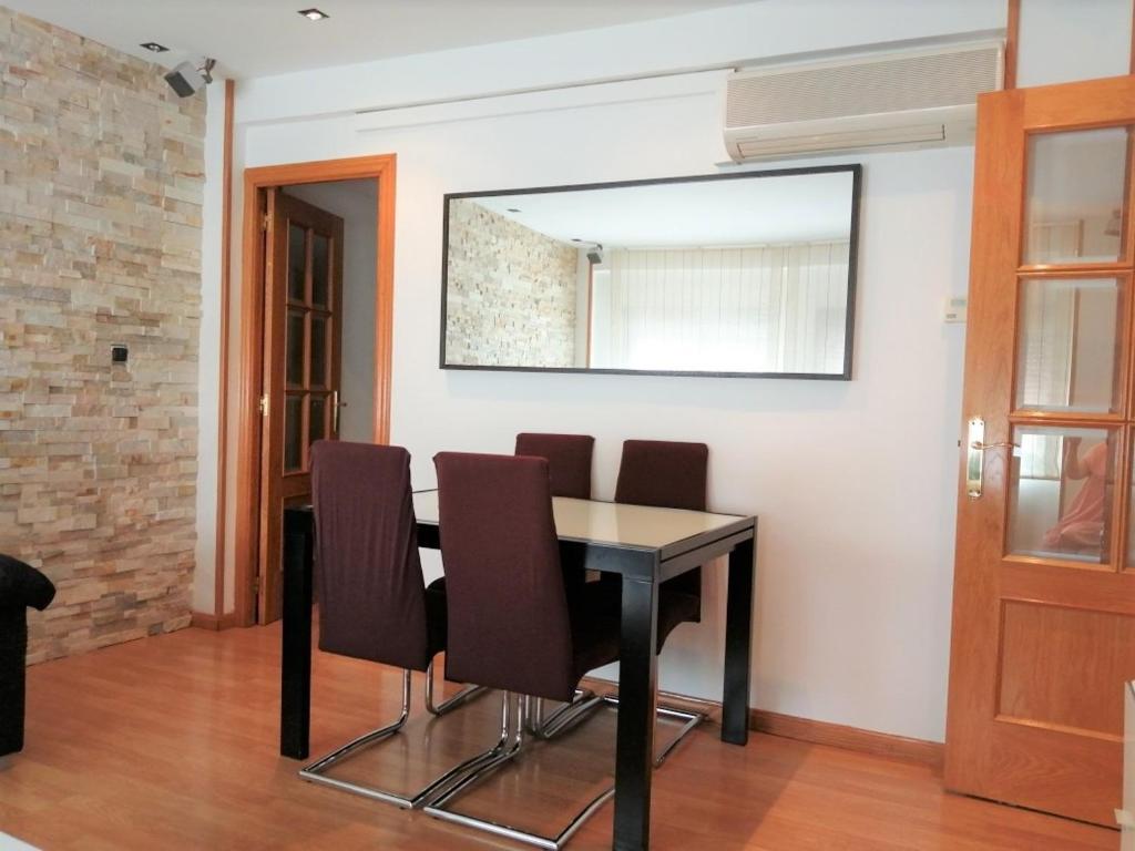 - une salle à manger avec une table, des chaises et un miroir dans l'établissement APARTAMENTO HUESCA, à Huesca