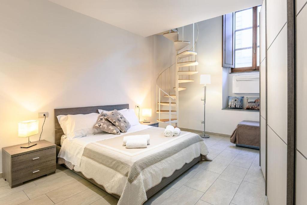 um quarto com uma cama e uma escada em espiral em Duomo Confort Suite em Florença