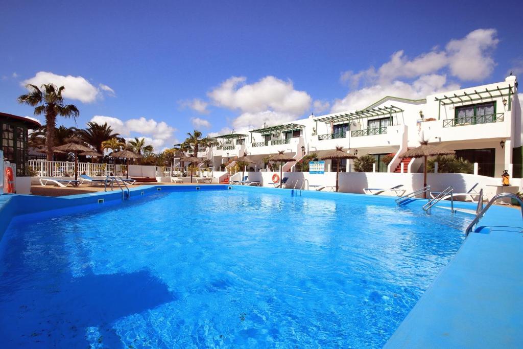 uma grande piscina azul em frente a um edifício em LUZ, CALMA Y SABOR MANRIQUEÑO EN MATAGORDA em Los Pocillos