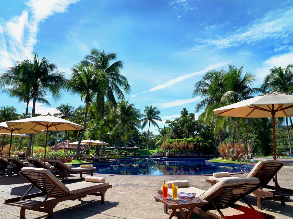梳邦再也的住宿－吉隆坡紹嘉納度假村，度假村的游泳池,配有椅子和遮阳伞