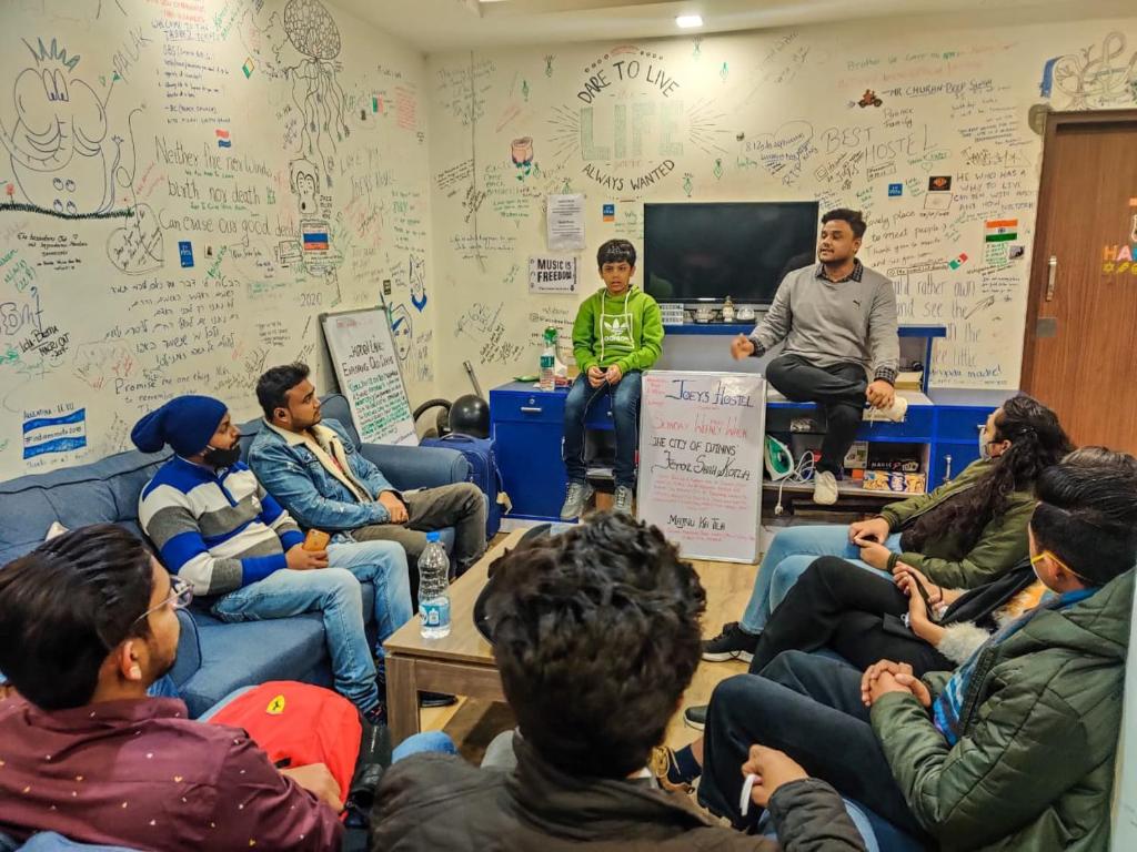 a group of people sitting in a room at Joey's Hostel Delhi - 20 mins from Railway Station in New Delhi