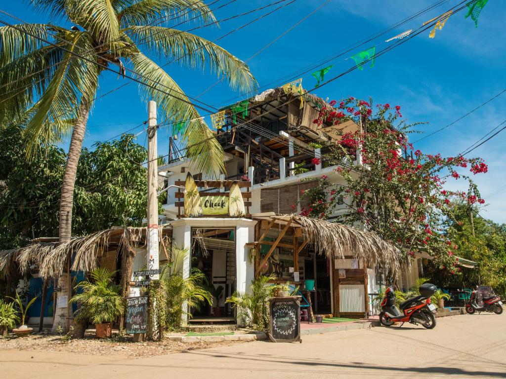 a building with a palm tree in front of it at Chaak in Puerto Escondido