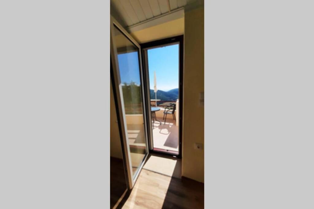a view from the hallway of a room with glass doors at Manto Apartments Lefkada in Évyiros