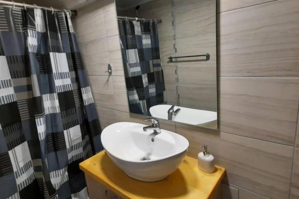 a bathroom with a sink and a mirror at Manto Apartments Lefkada in Évyiros