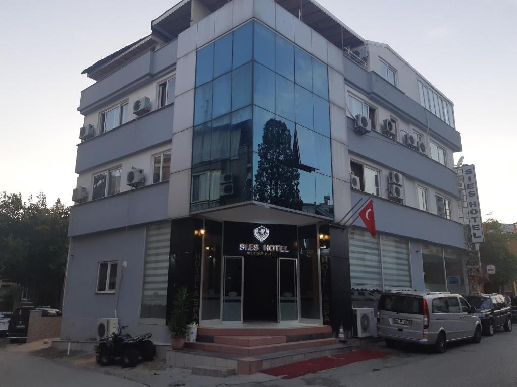 a building with a car parked in front of it at SİES OTEL in Antalya
