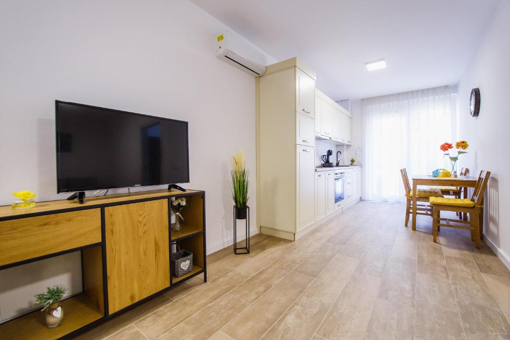 een woonkamer met een flatscreen-tv op een entertainmentcentrum bij Lovely Home at West Residence in Oradea