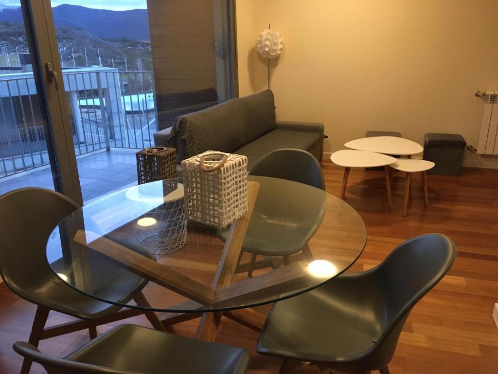 sala de estar con mesa de cristal y sillas en Apartamentos Las Margas Golf Formigal Ordesa, en Sabiñánigo
