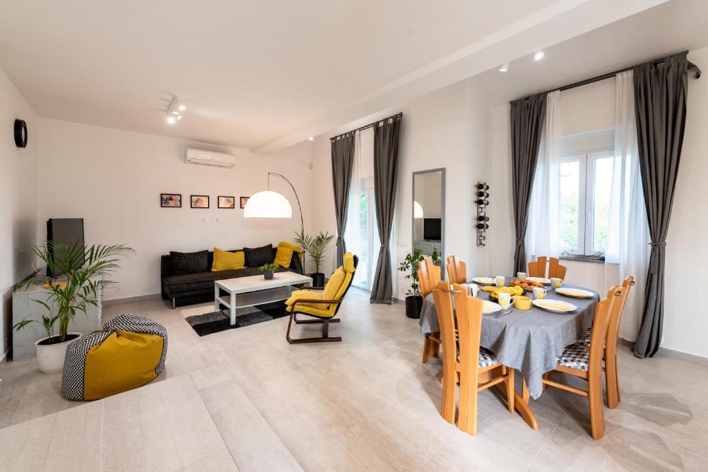 里耶卡的住宿－Kuća za odmor Diraki，客厅配有桌子和黄色椅子