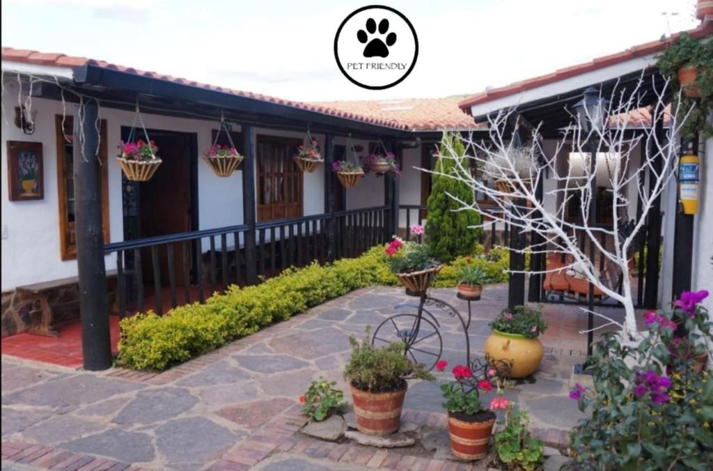 a house with potted plants in front of it at Hotel Quinta de Santa Ana in Tibasosa