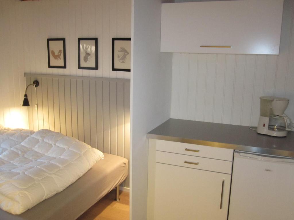 cocina blanca con cama y barra en Lystskov Camping & Cottages en Korsør