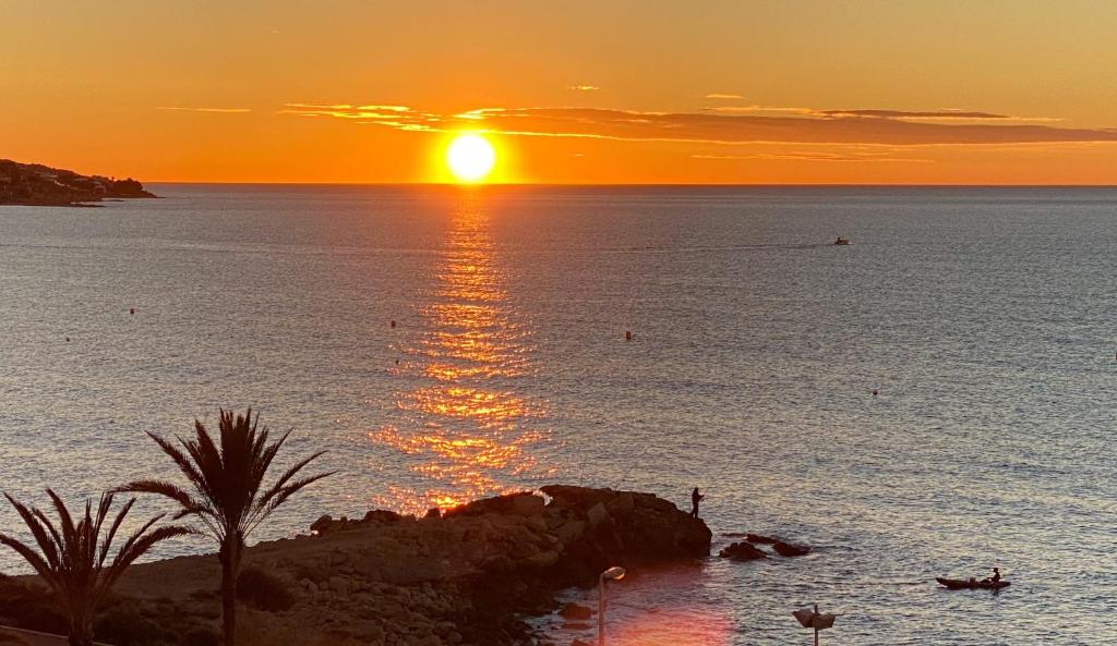 - un coucher de soleil sur l'océan dans l'établissement 13 Rocafel 7 Playa Albufereta Alicante, à Alicante