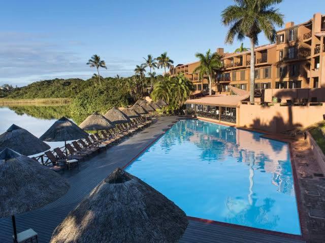 a large swimming pool with umbrellas and a hotel at San Lameer Villa, Beach Estate, South Coast KZN in Marina Beach