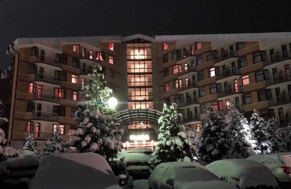 een gebouw met sneeuw bedekte bomen ervoor bij Flora Apartment 612A in Borovets