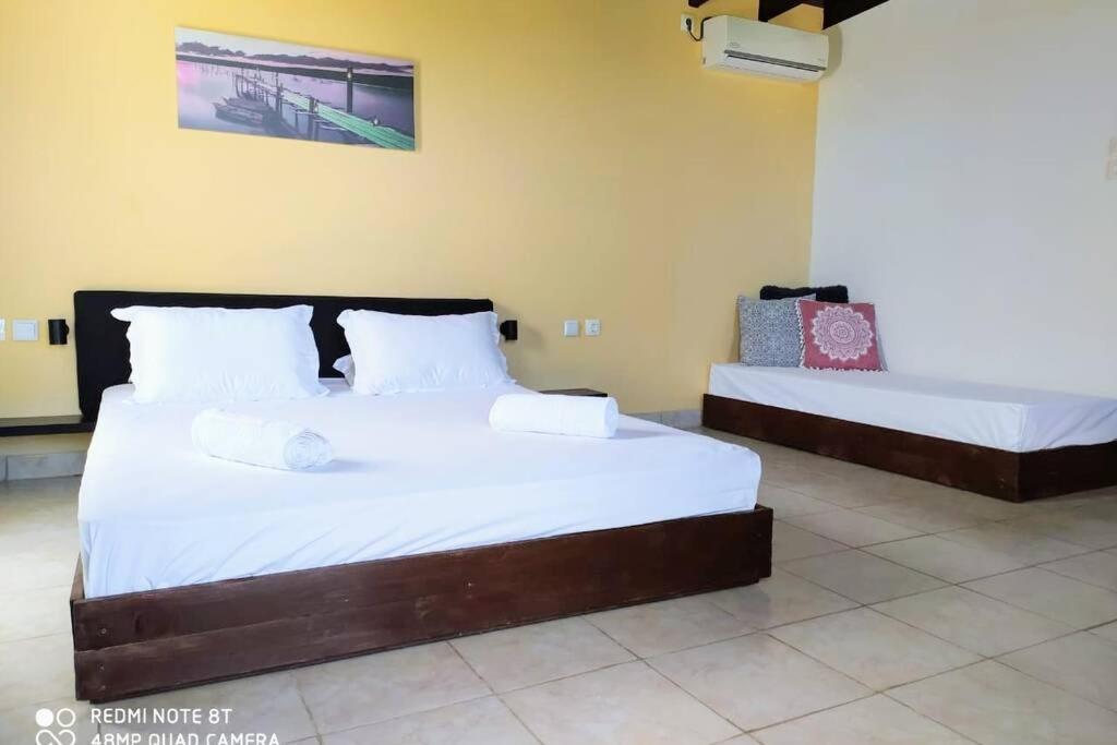 1 dormitorio con 2 camas con sábanas blancas en Raisin House en Koukounariá