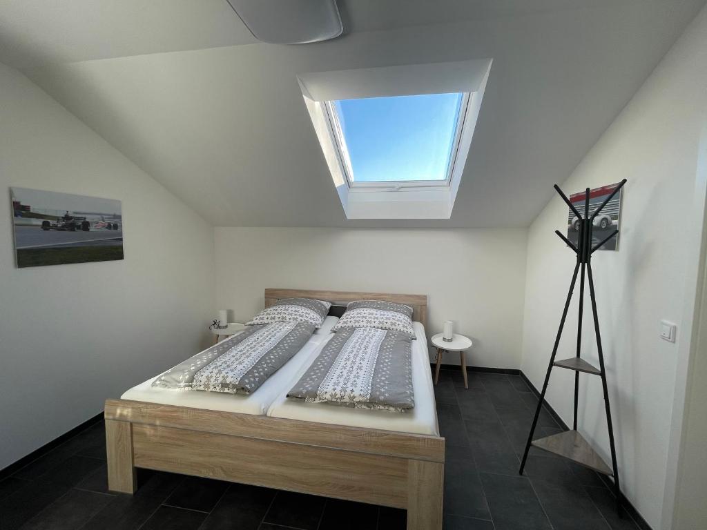 Schlafzimmer mit einem Bett und einem Fenster an der Decke in der Unterkunft Gästehaus Veenstra in Kelberg