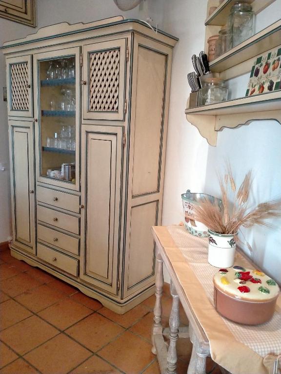 a large wooden cabinet in a kitchen with a table at Villa Rossi in Polignano a Mare