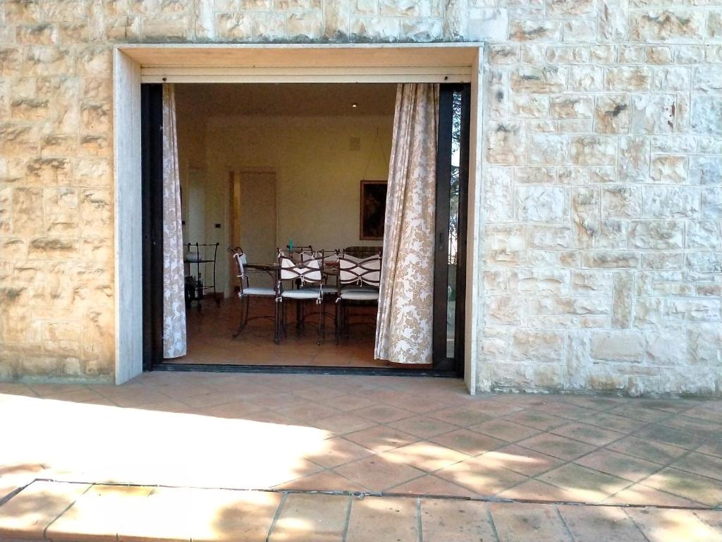 a patio with a table and chairs and a stone wall at Villa Rossi in Polignano a Mare