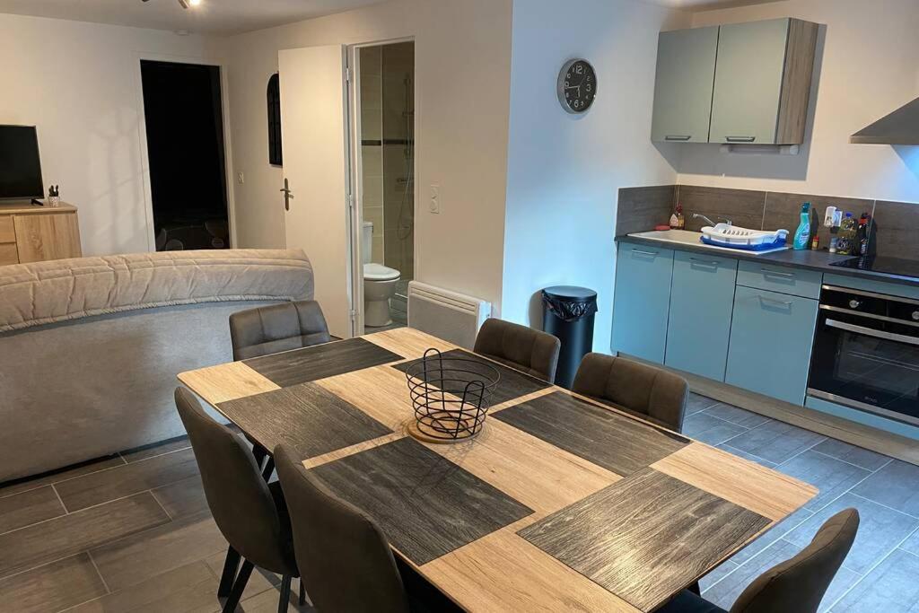 eine Küche mit einem Holztisch und Stühlen im Zimmer in der Unterkunft La bâtisse de Chabot N°1 ( 4 couchages ) in Montluçon