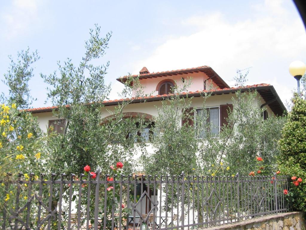 a house with a fence and flowers at La Locanda Cuccuini in Cavriglia