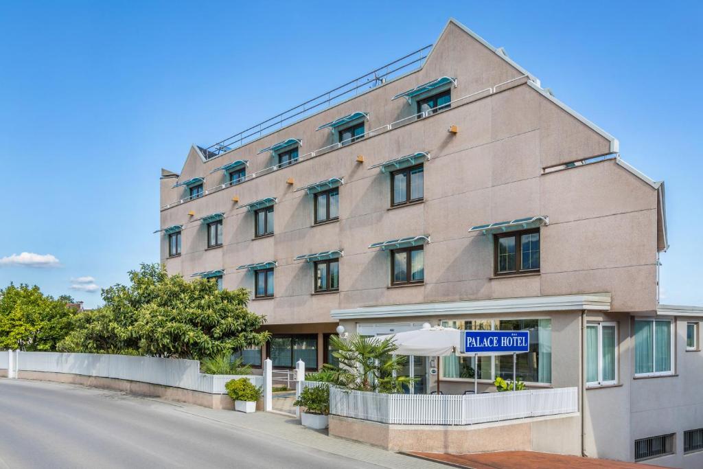 un edificio con un letrero que lee hacer turnos en Aviano Palace Hotel, en Aviano