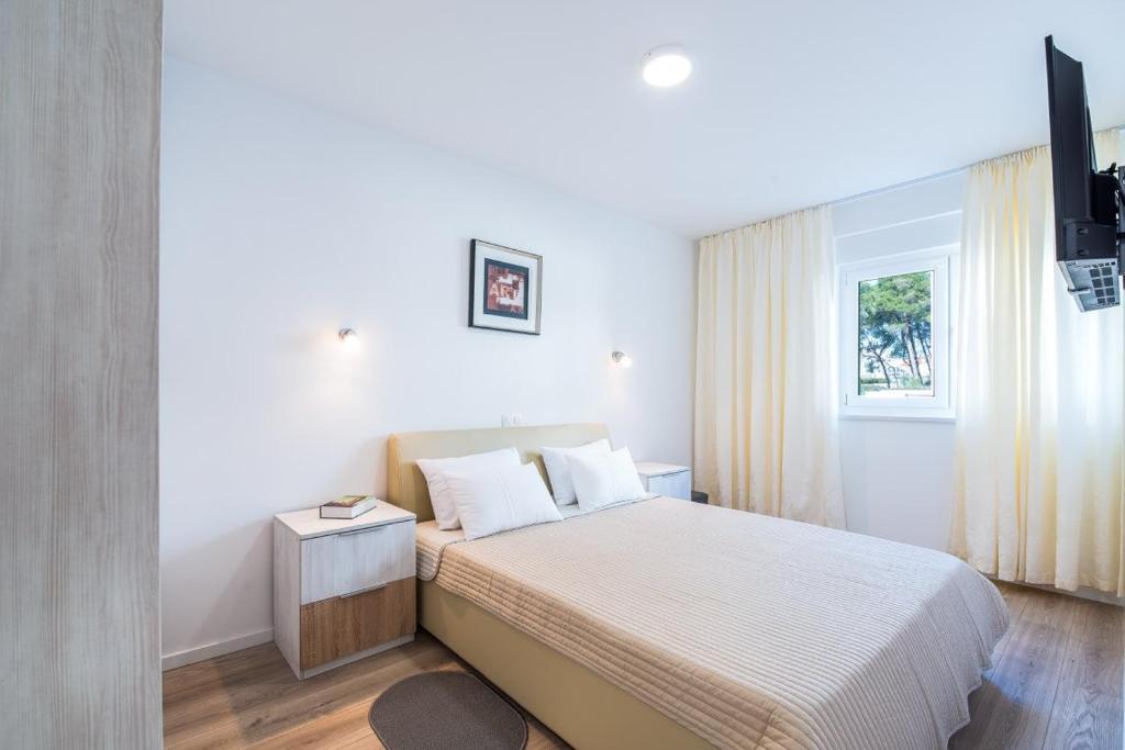 um quarto branco com uma cama e uma janela em Apartment Maria Vir em Vir