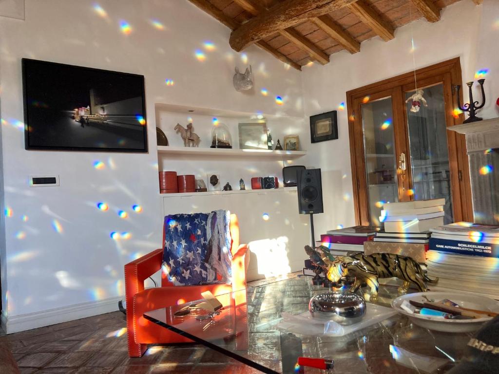 ein Wohnzimmer mit einem Glastisch und einem Stuhl in der Unterkunft Cesare Magli & Figli Residenza D'Epoca Luxury Rooms in Molinella