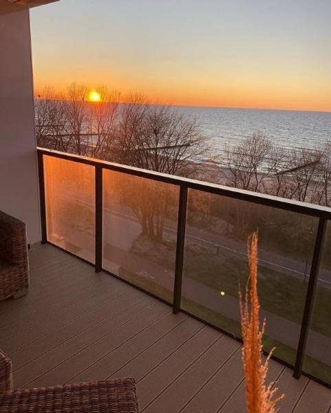 balkon z widokiem na ocean o zachodzie słońca w obiekcie APARTLUX Seaside Park - bezpośredni widok na morze w Kołobrzegu