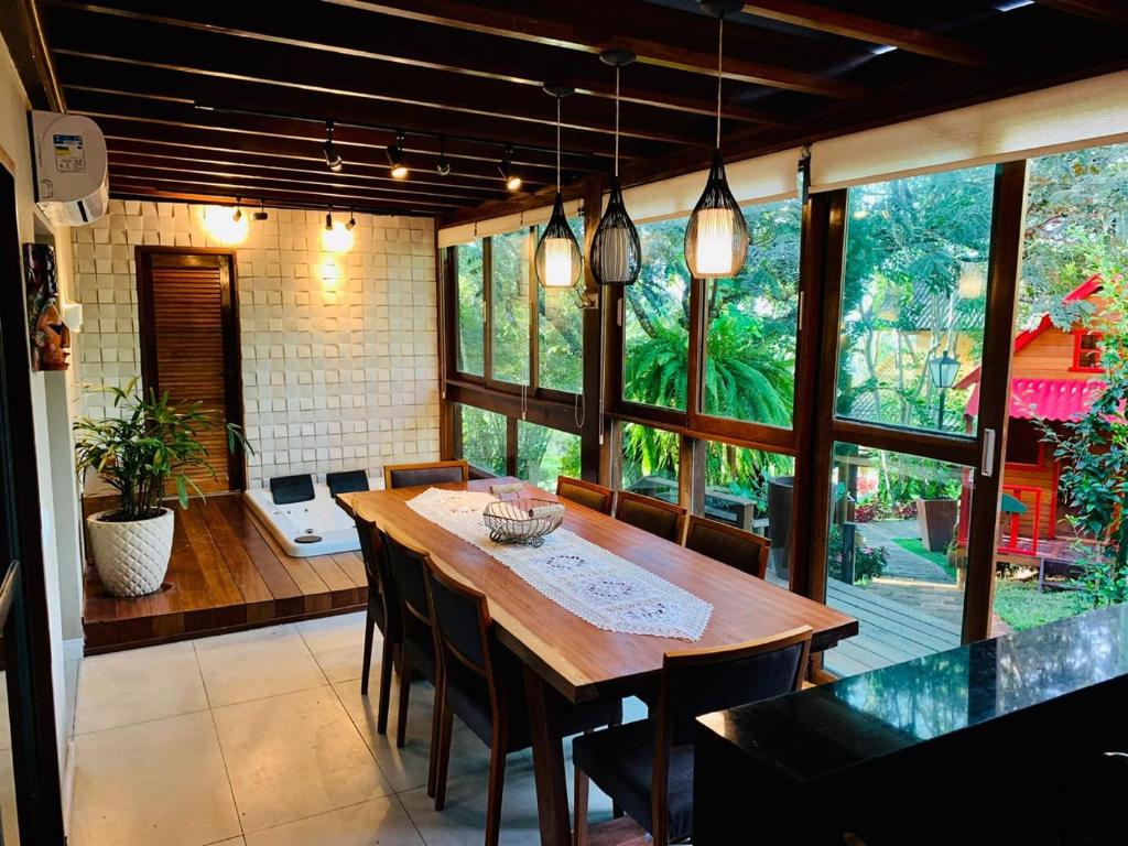 una sala da pranzo con tavolo e sedie in legno di Casa luxo 10 pessoas com jacuzzi Chã Grande PE a Recife
