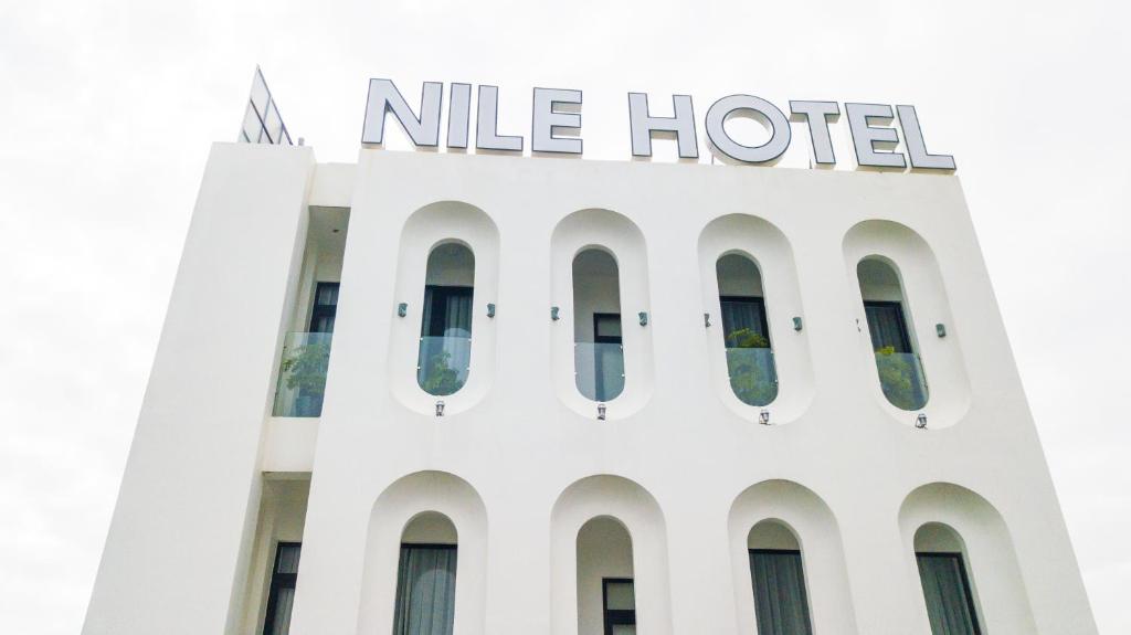 a white hotel with a nile hotel sign on top at Nile Hotel in Tuy Hoa