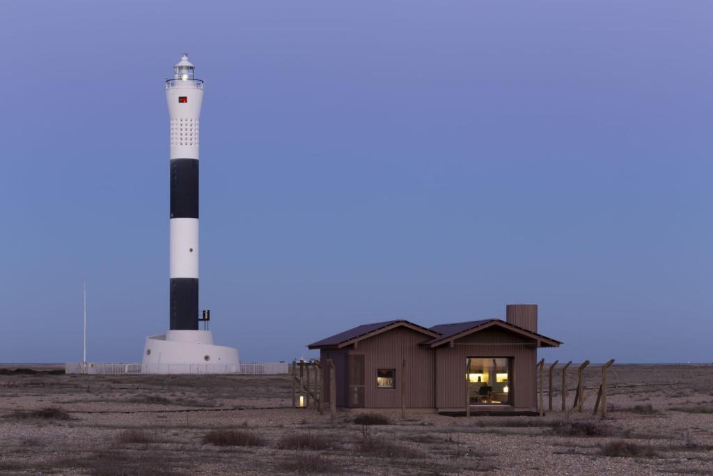 a small building in front of a lighthouse at Radar by Bloom Stays in Littlestone-on-Sea