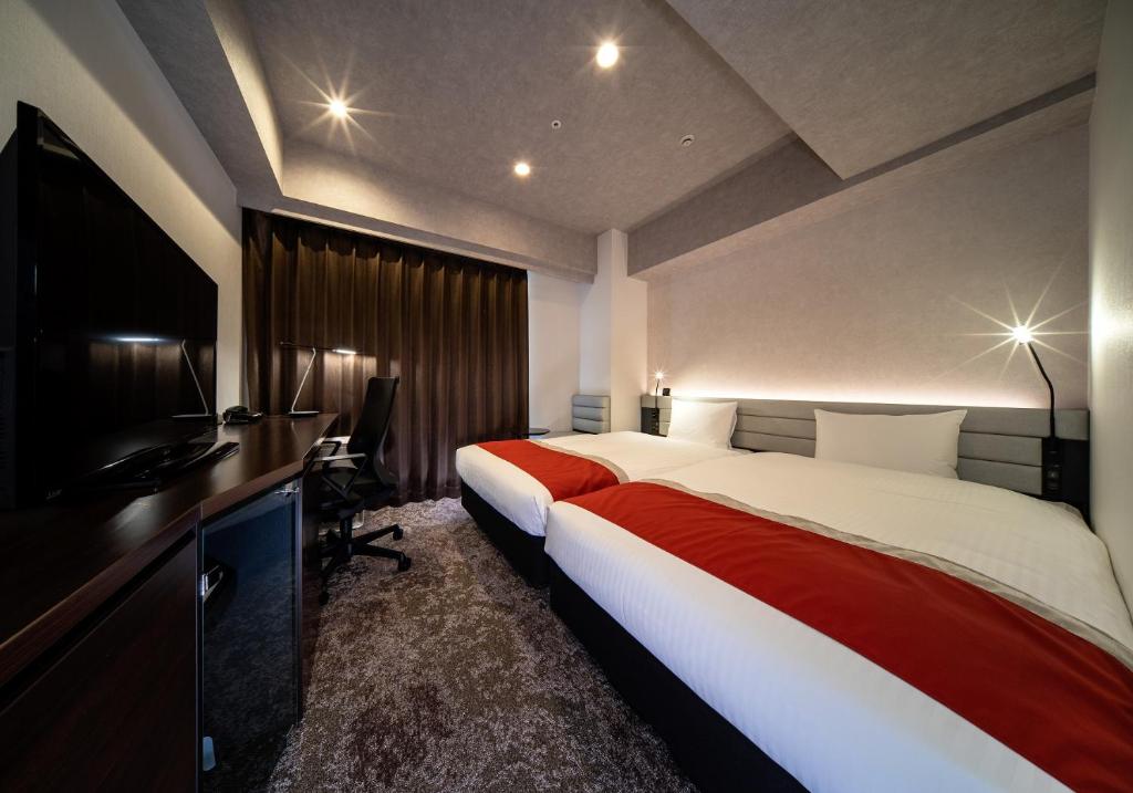 Tempat tidur dalam kamar di DEL style Ikebukuro Higashiguchi by Daiwa Roynet Hotel