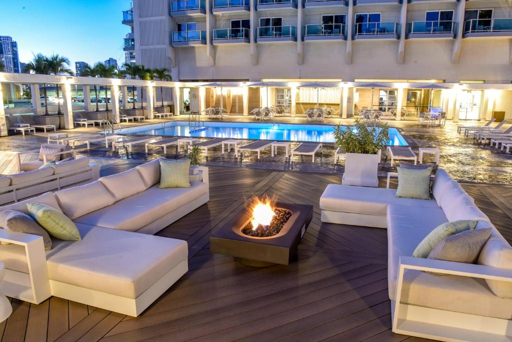 eine Hotelterrasse mit einer Feuerstelle und einem Pool in der Unterkunft Ala Moana Hotel - Resort Fee Included in Honolulu