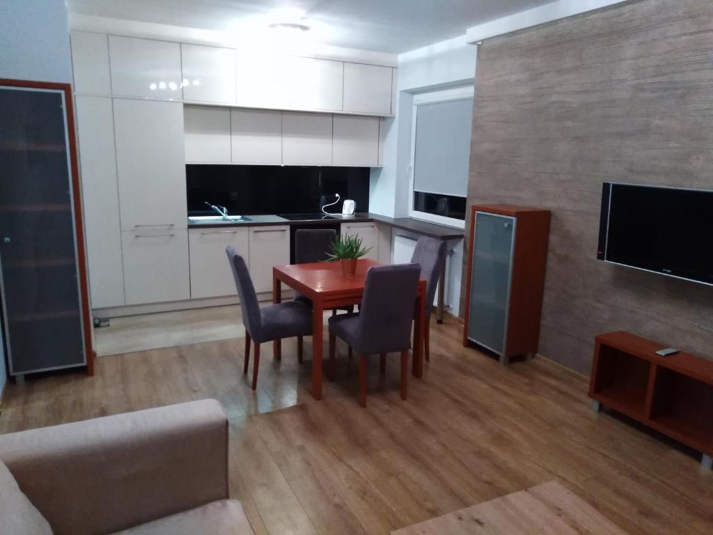 a kitchen and dining room with a table and chairs at Apartament MAZURIA2 in Ełk