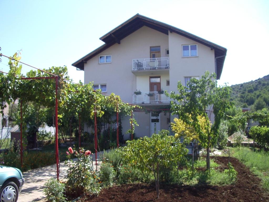 une maison avec un jardin en face dans l'établissement Apartment Dalmatien, à Raslina