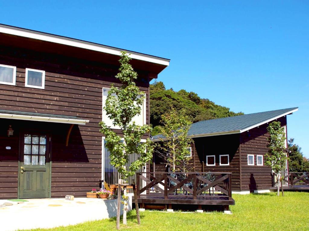 a barn with a tree growing on the side of it at Mt Ichibata Cottage in Izumo