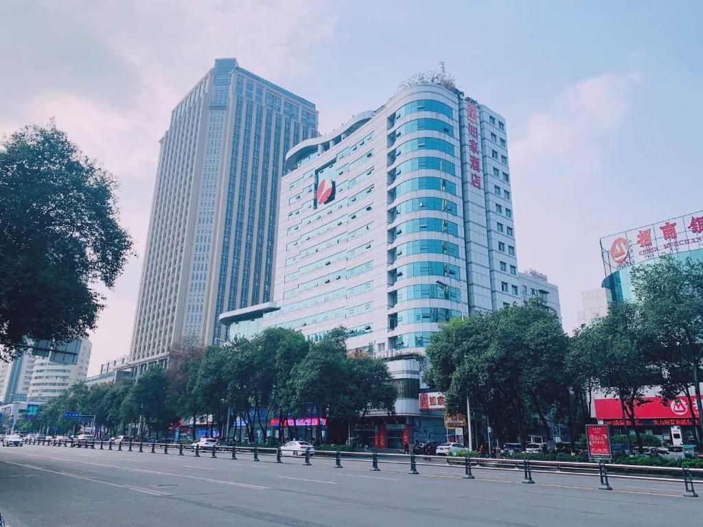 a large building with a sign on it in a city at Home Inn Mianyang People'S Park in Mianyang