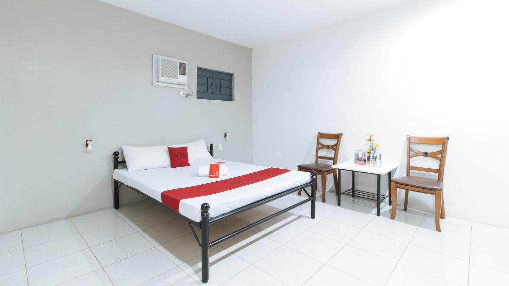a bedroom with a bed and a table and chairs at RedDoorz near SM Calamba in Laguna