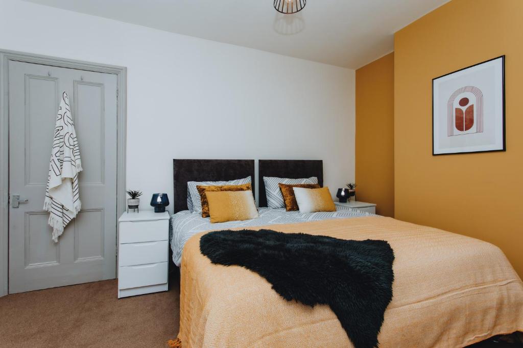 a bedroom with a large bed with a black blanket at BRAND NEW TOWNHOUSE IN RUGBY in Rugby