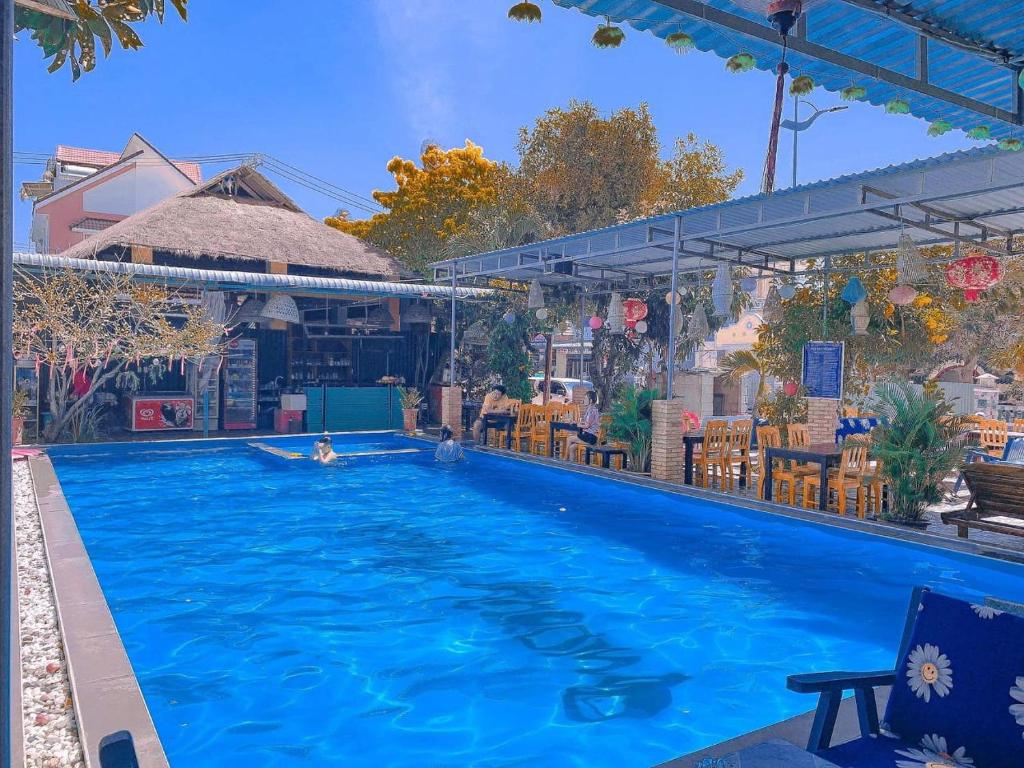 una gran piscina con una persona en el agua en Song Huong Hotel Mui Ne en Mui Ne