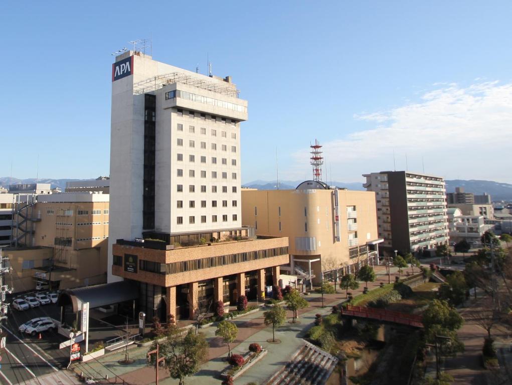 un grand bâtiment blanc au milieu d'une ville dans l'établissement APA Hotel Tottori Ekimae Minami, à Tottori