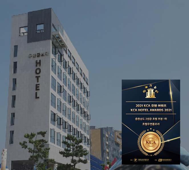 a sign in front of a tall building at Hotel Wooyeon Flora in Boryeong