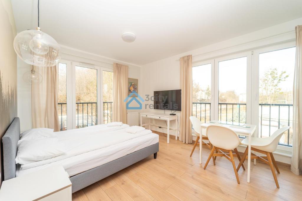 a bedroom with a bed and a table and chairs at Aura Sopot Studio Apartments in Sopot