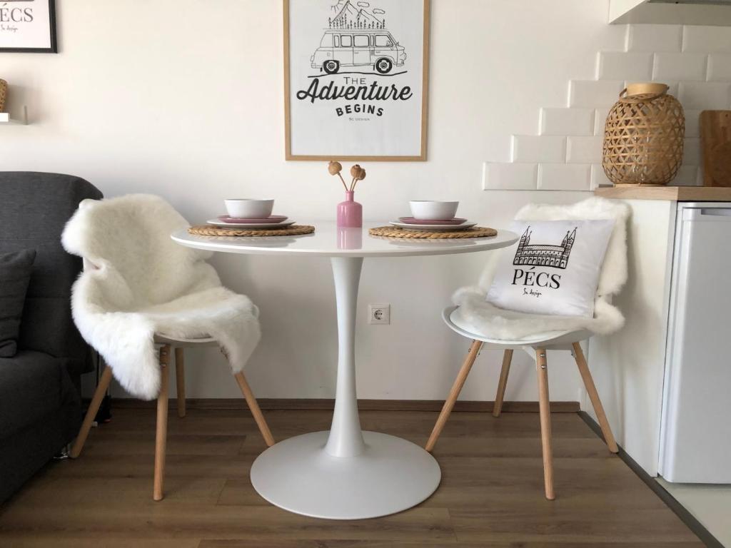 ペーチにあるSC design Home Apartmanのリビングルーム(白いテーブル、椅子2脚付)