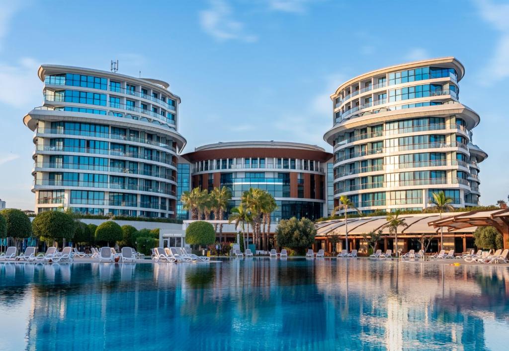 two tall buildings with chairs in front of a pool at Baia Lara Hotel in Lara