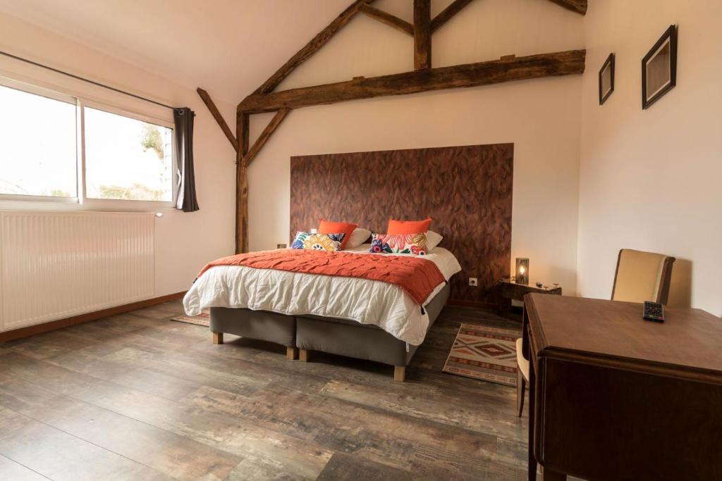 una camera da letto con un letto grande con cuscini arancioni di Maison entre Campagne et Foret a Aspret-Sarrat