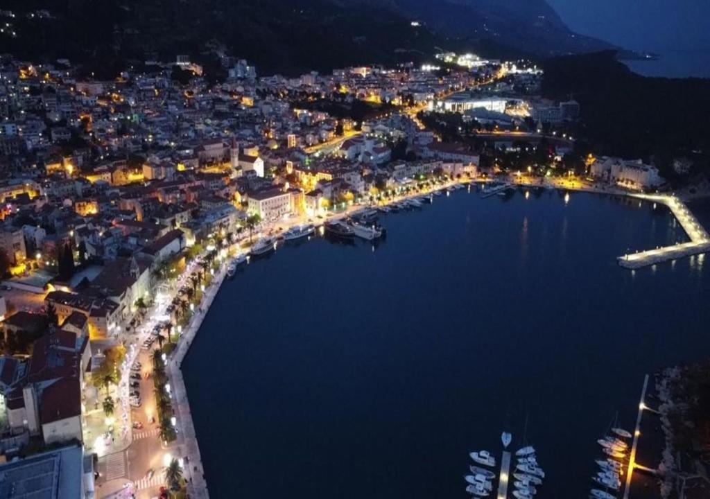 una vista aerea di una città di notte di Apartments & Rooms Alagić a Makarska