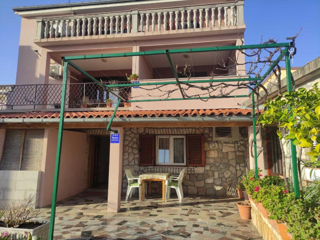 a house with a table and chairs in front of it at Apartman Budimir in Cres
